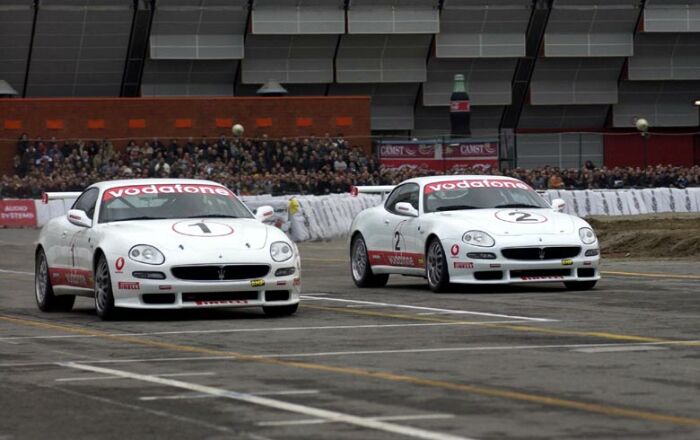 Luciano Burti and Andrea Bertolini demonstrate the Maserati Trofeo sportscar around the Bologna Motor show's circuit