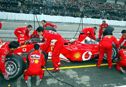 the Ferrari team undertake pitstop simulations at the 2002 Bologna Motor Show