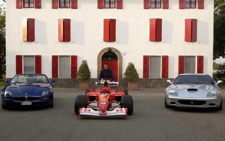 Michael Schumacher poses with his Formula 1 World Championship winning Ferrari F2002 and his road cars, a new Ferrari 575M and Maserati Spyder