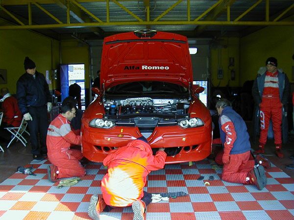 Gabriele Tarquini watches the Nordauto mechanics working on his Alfa Romeo 156GTA