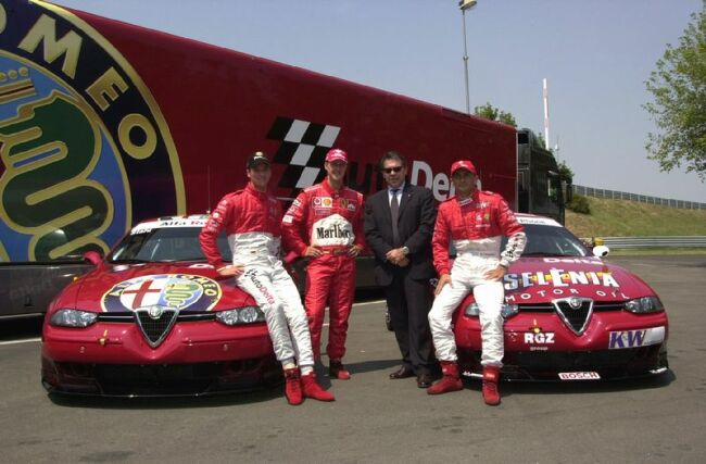 Sebastian Stahl, Michael Schumacher, Daniele Bandiera and Gabriele Tarquini pose with two Alfa Romeo 156GTA ETCC cars after a test session earlier this summer