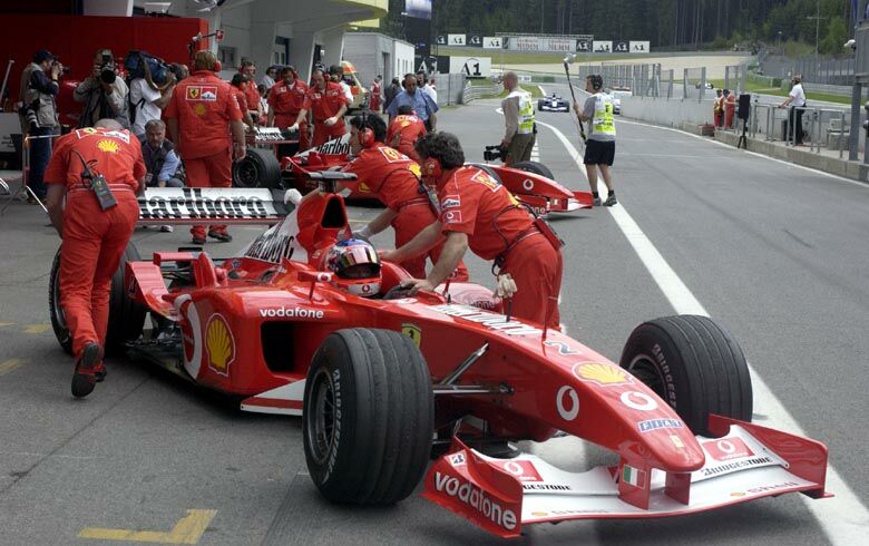 Rubens Barrichello's Ferrari F2002 is pushed into the garage during free practice