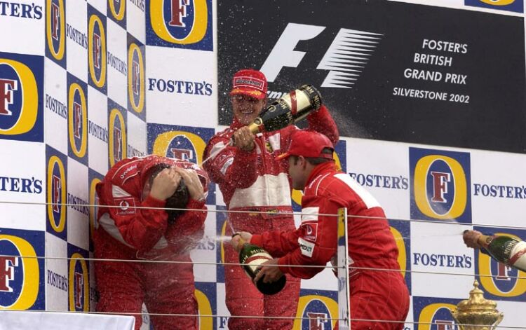 the Ferrari drivers soak Ross Brawn in Champagne