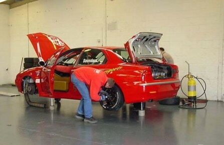 Graham Saunders' GA Motorsport Alfa Romeo 156 is worked on in the pit garage